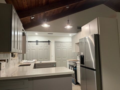 A kitchen with stainless steel appliances and a sliding barn door.