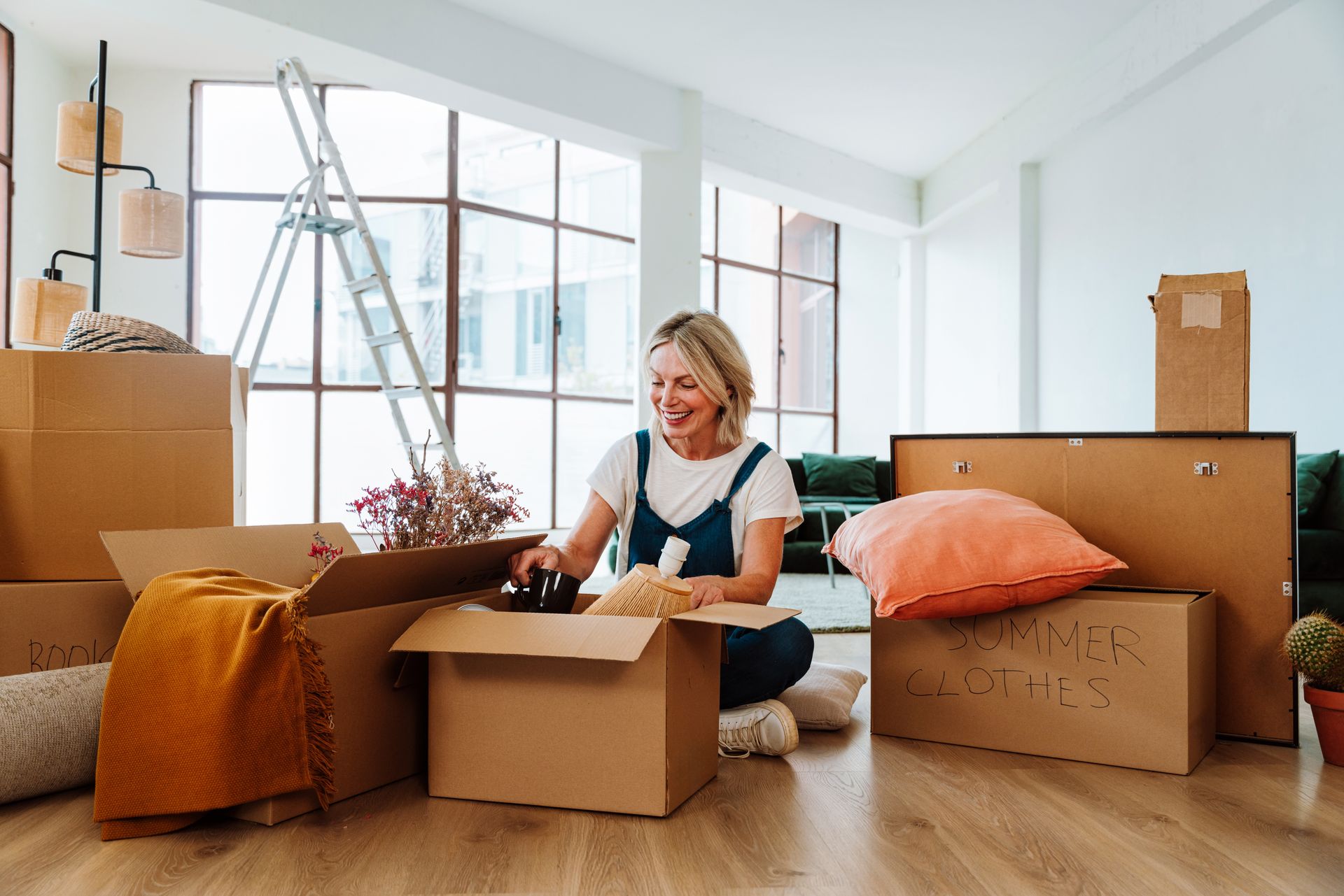 Woman packing boxes in a bright living room during a move