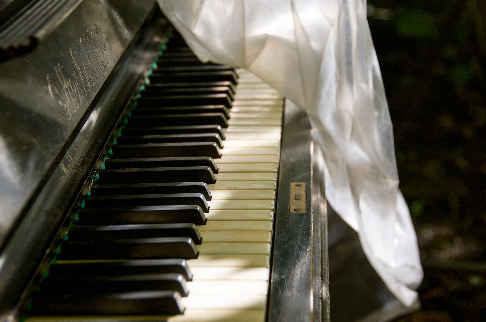 A piano with a white cloth draped over it