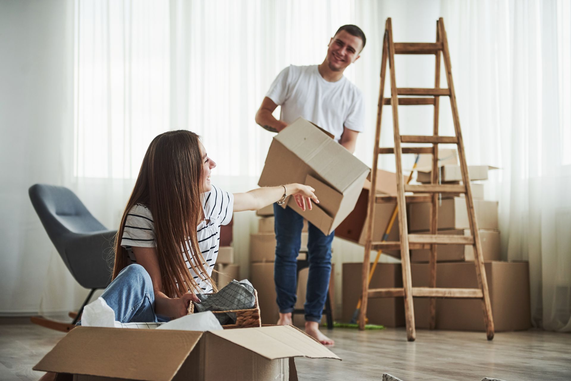 A man and a woman are moving into a new home.