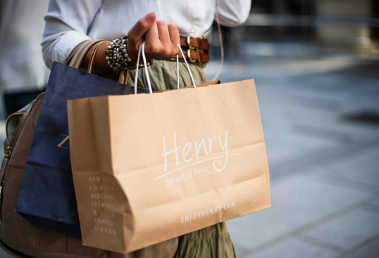 A woman is holding a henry bag in her hands.