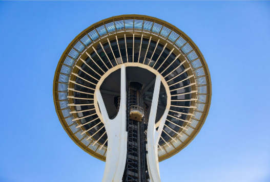 Looking up at the space needle against a blue sky.