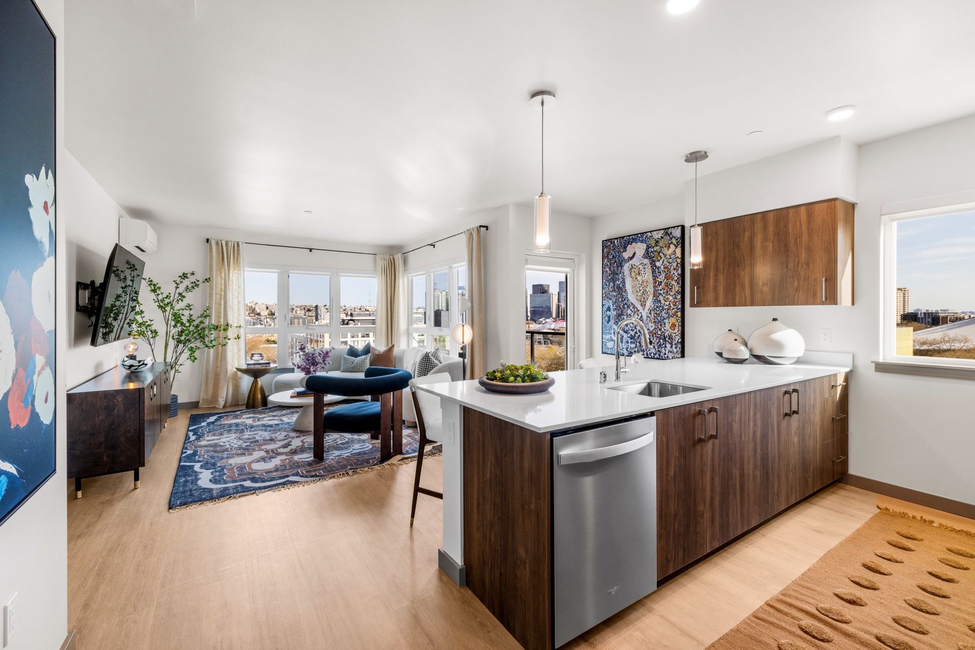A kitchen with stainless steel appliances and wooden cabinets in a living room.