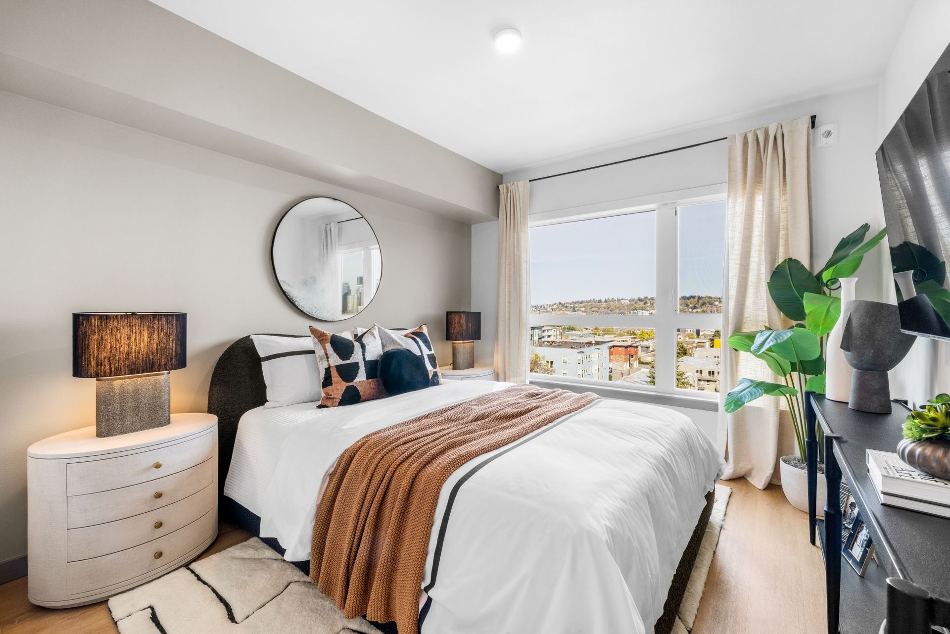 A bedroom with a large bed , dresser , and television.
