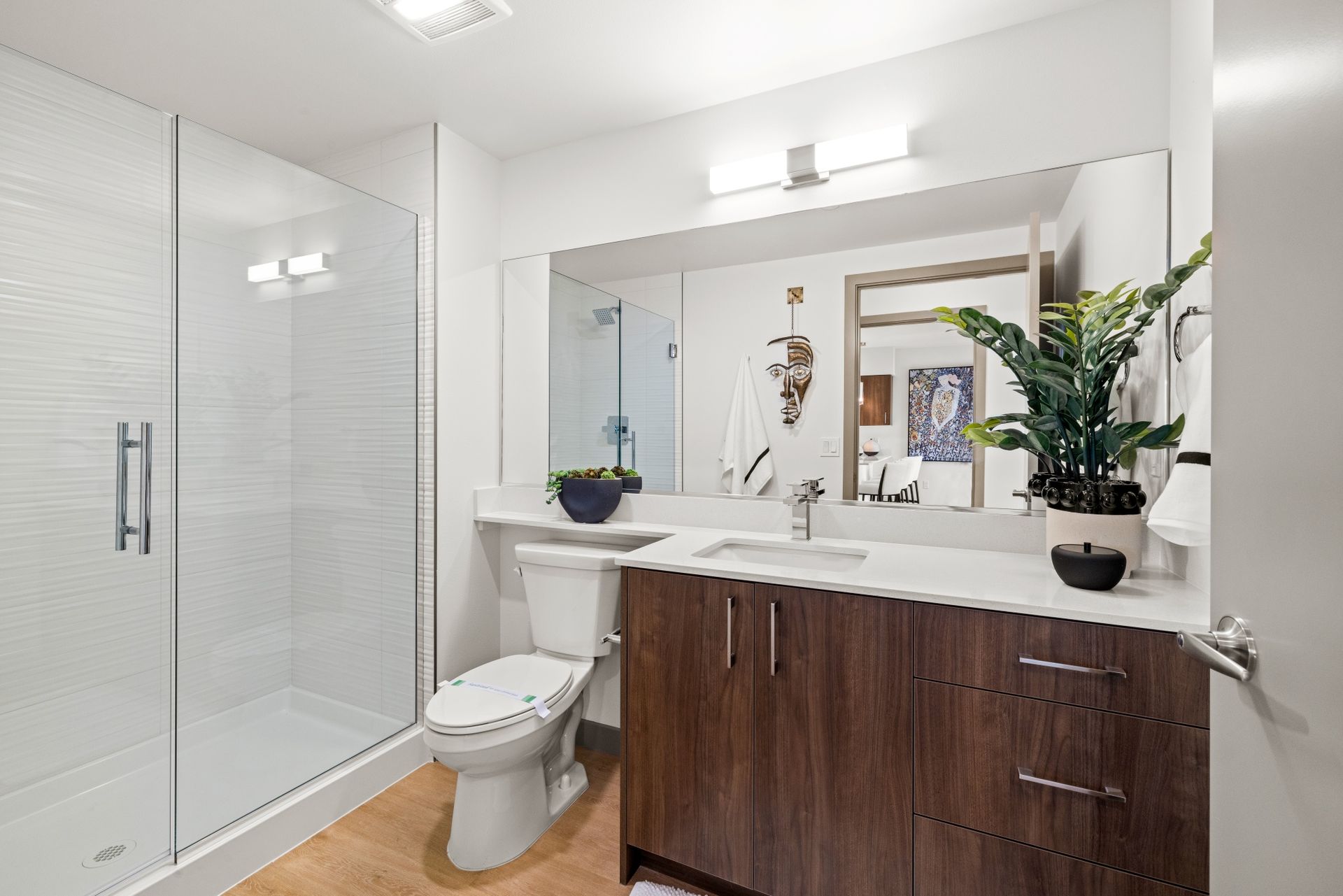 A bathroom with a toilet , sink , and walk in shower.
