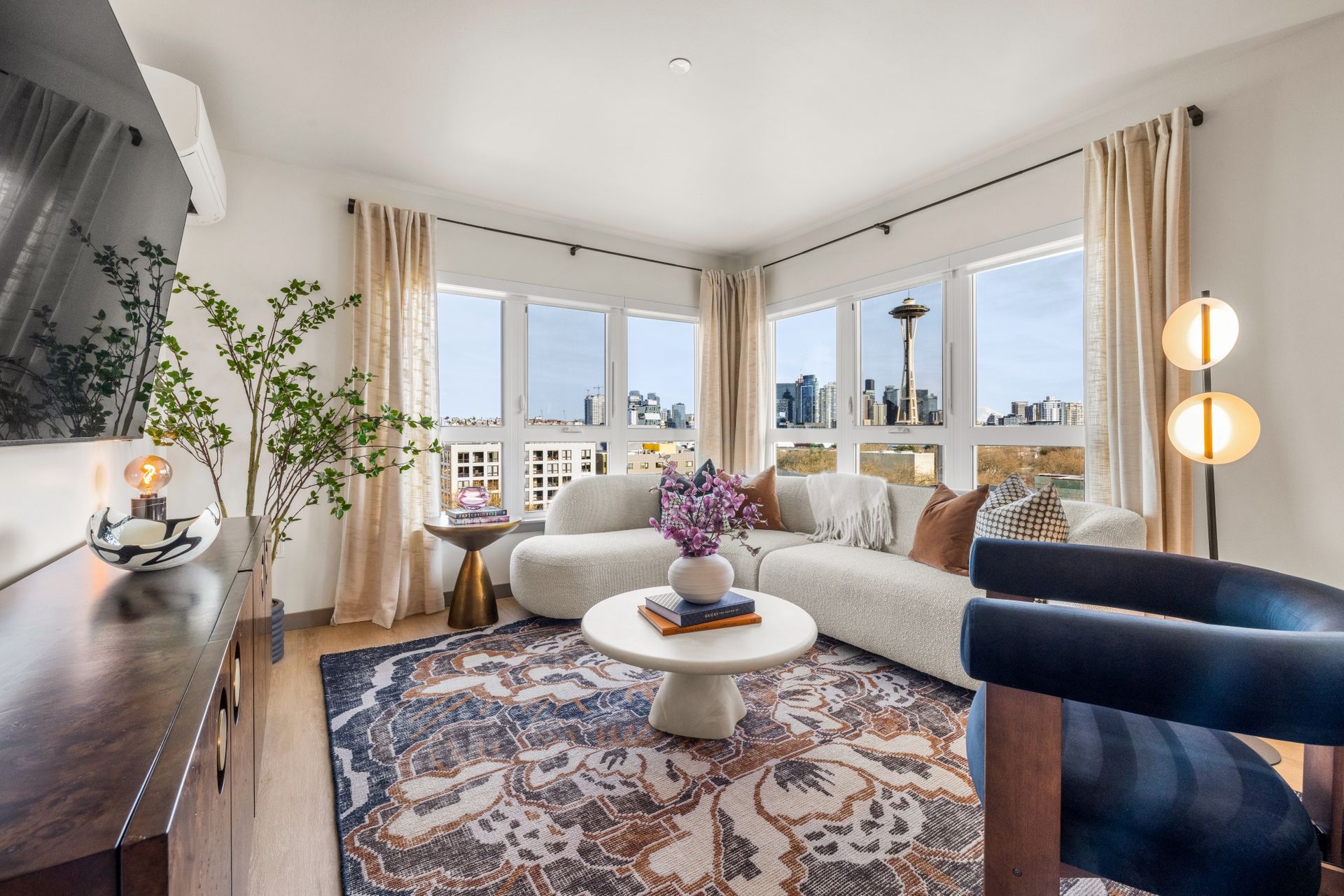 A living room with a couch , chair , coffee table and television.