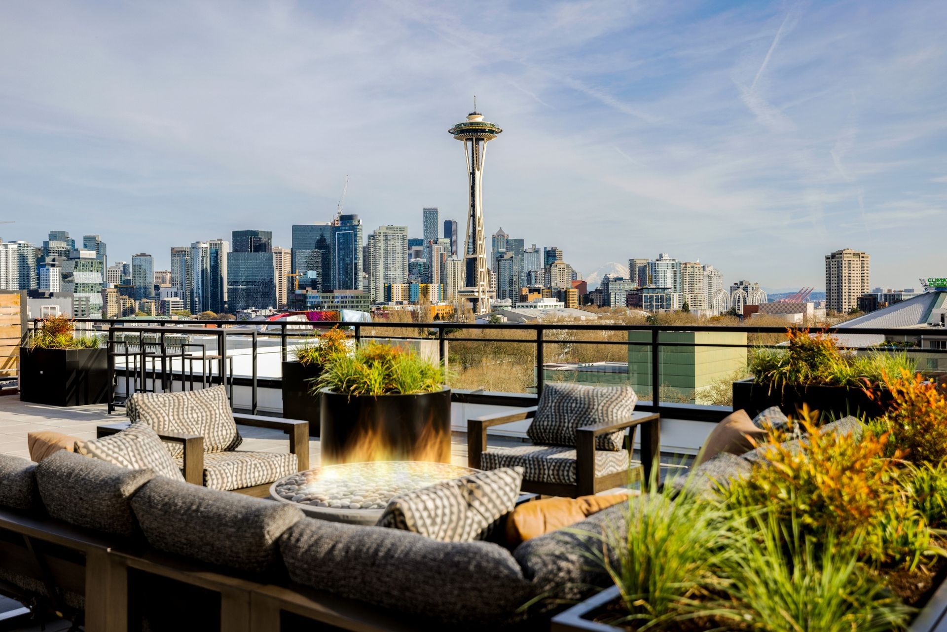 A rooftop patio with a view of the city skyline at night.