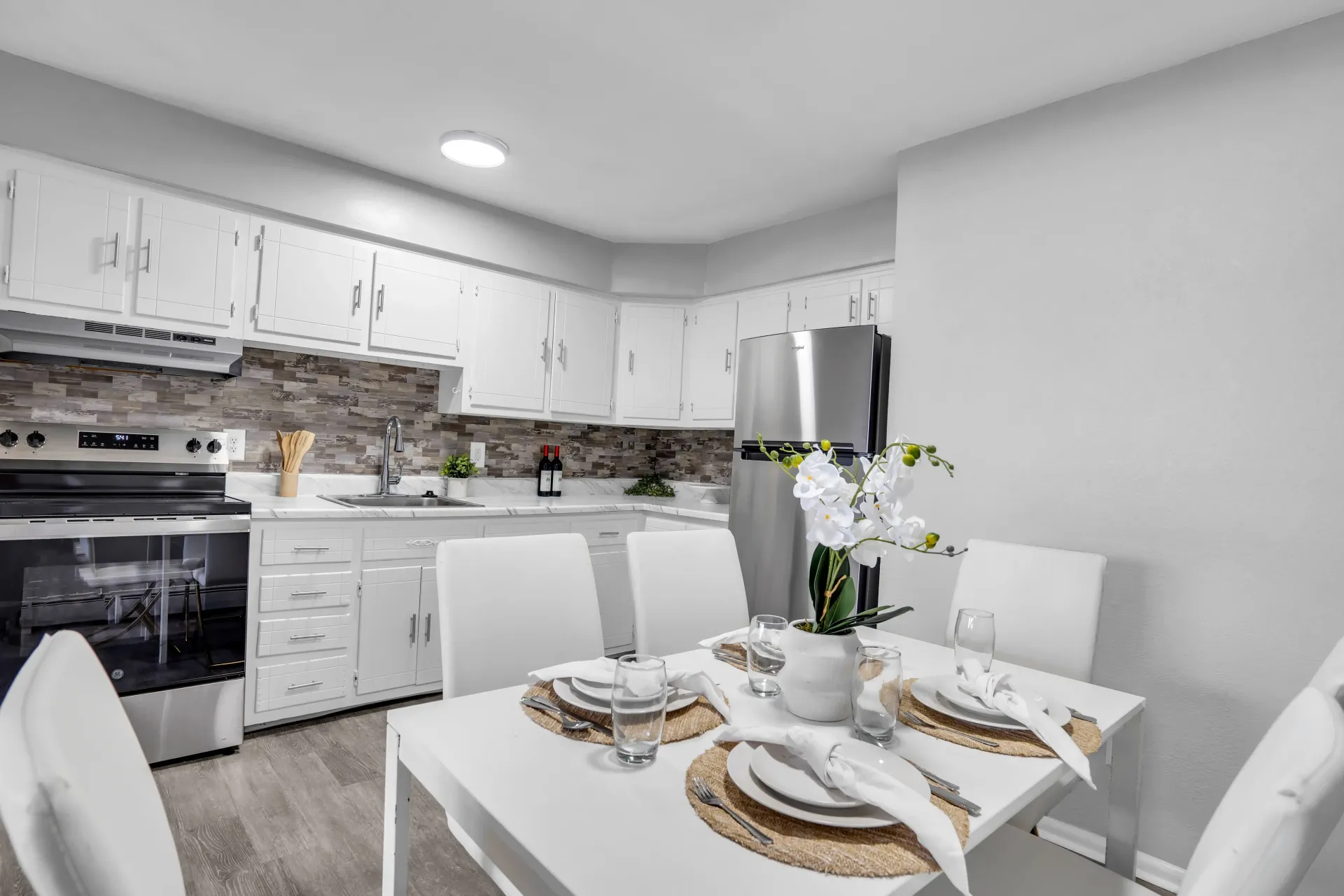 Kitchen and dining space with white cabinetry at Town Bank Manor Apartments in NJ