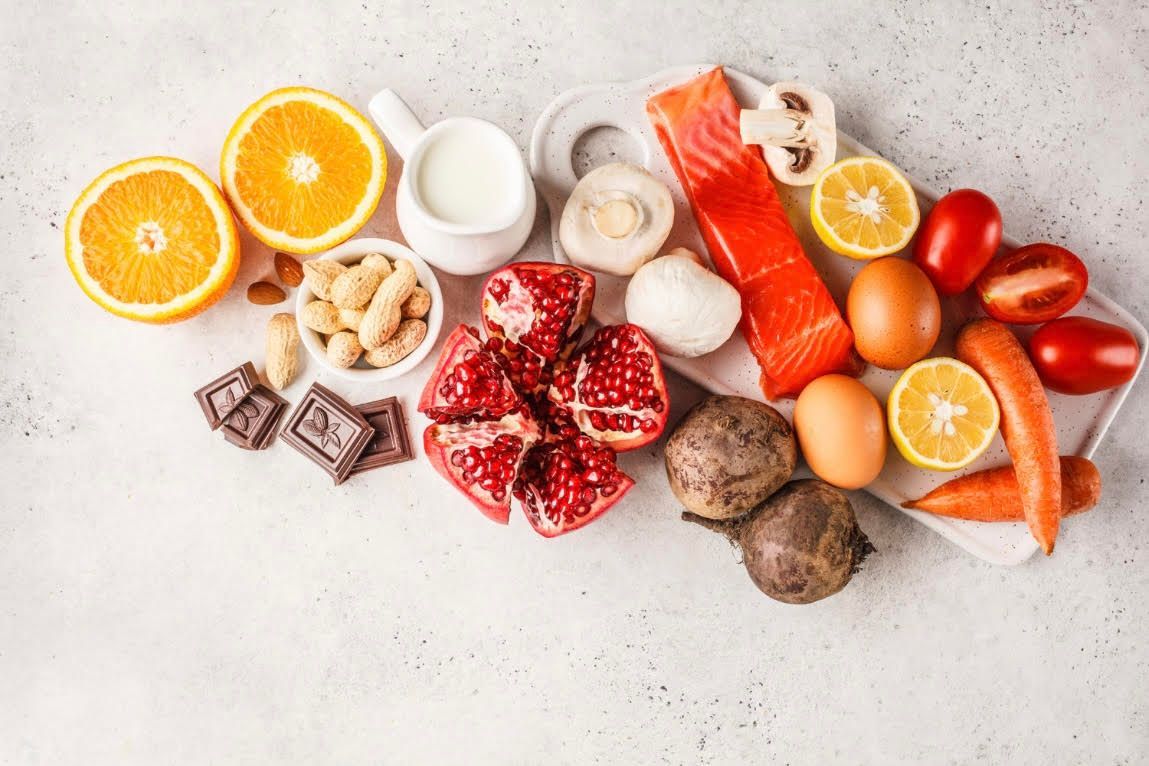 A variety of fruits and vegetables are sitting on a table.