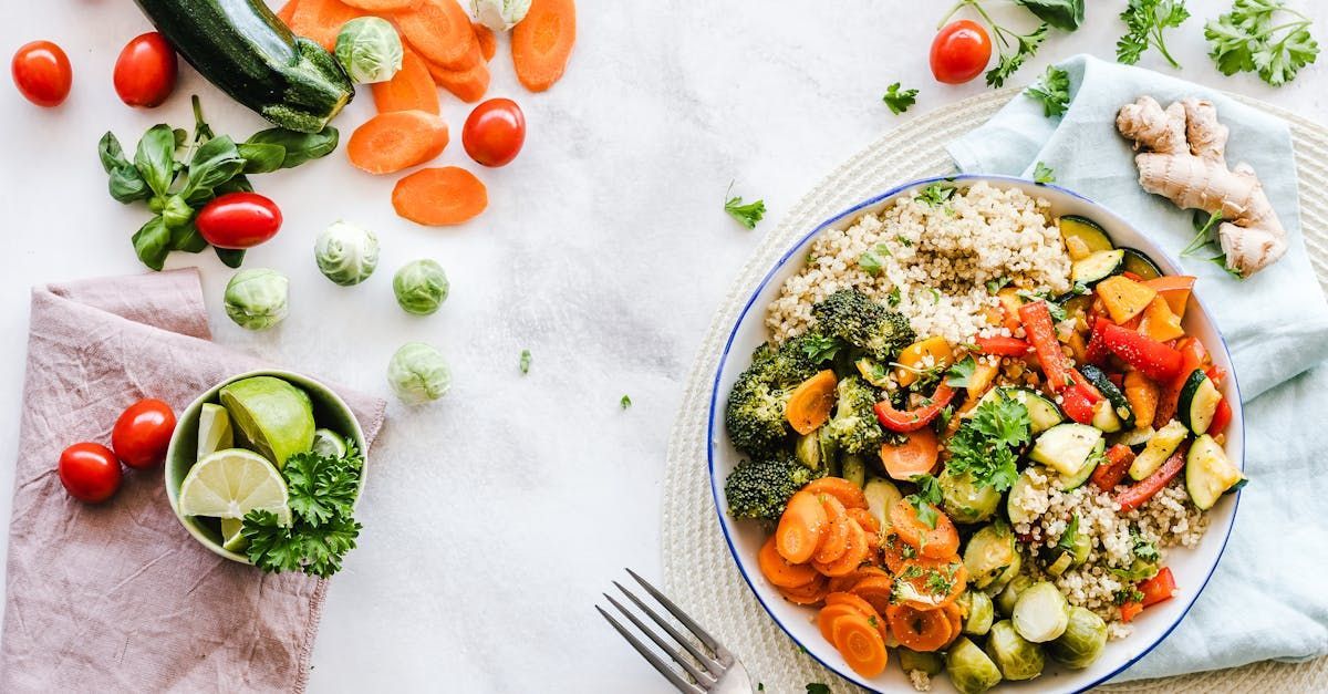 A bowl of vegetables and rice on a table with a fork.