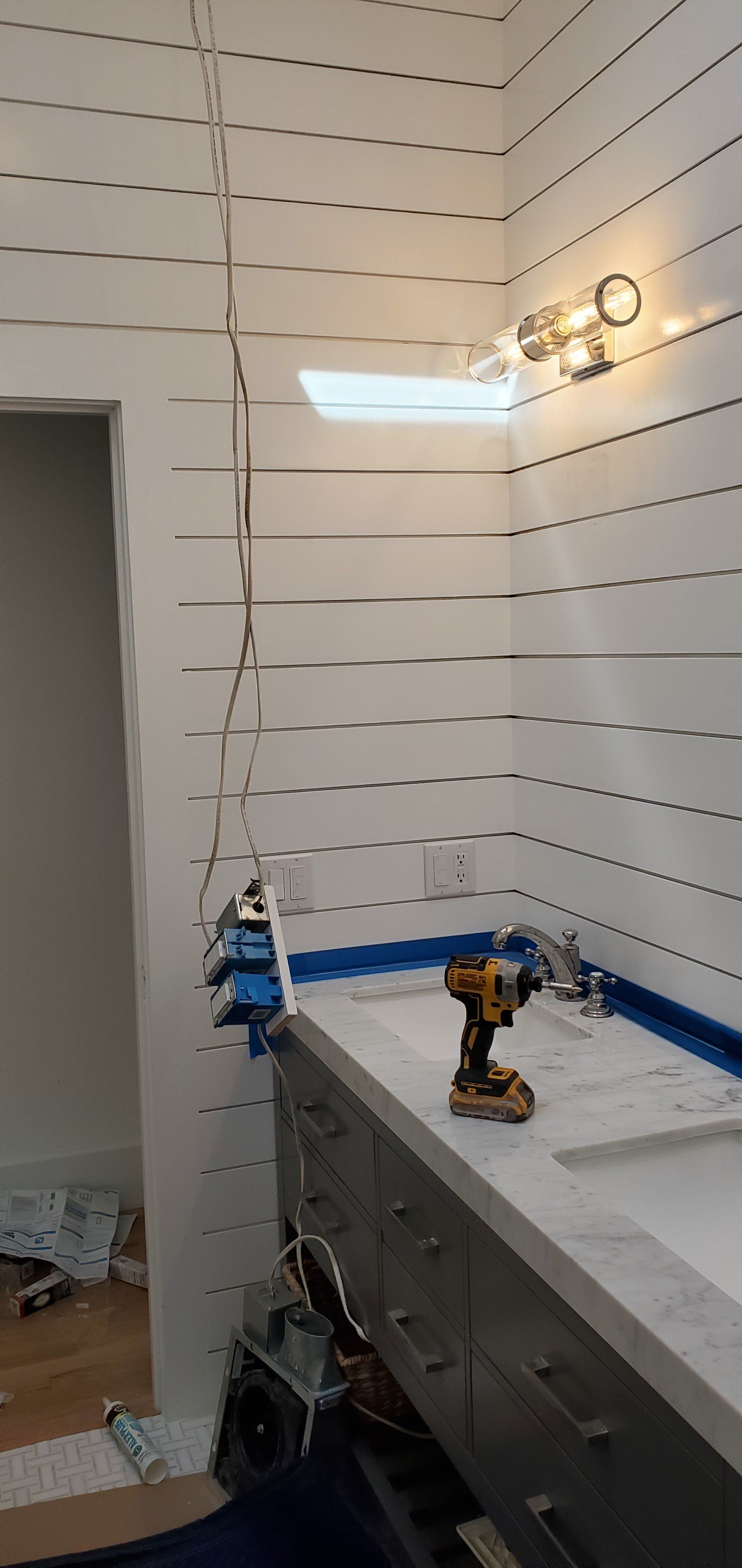 a bathroom with a sink and a drill on the counter .