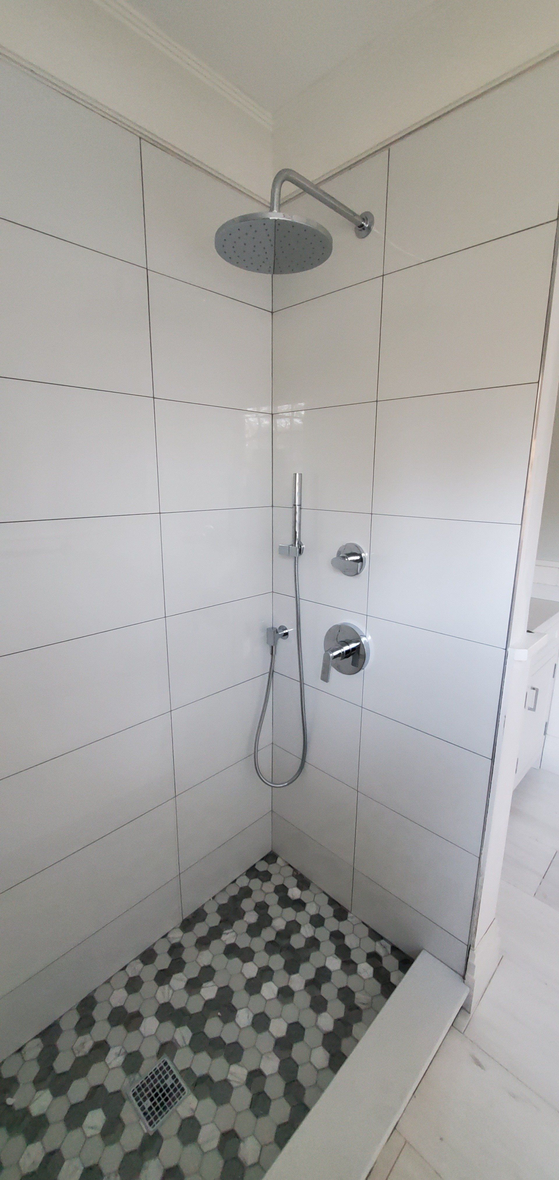 a shower with a shower head and a tiled floor in a bathroom .