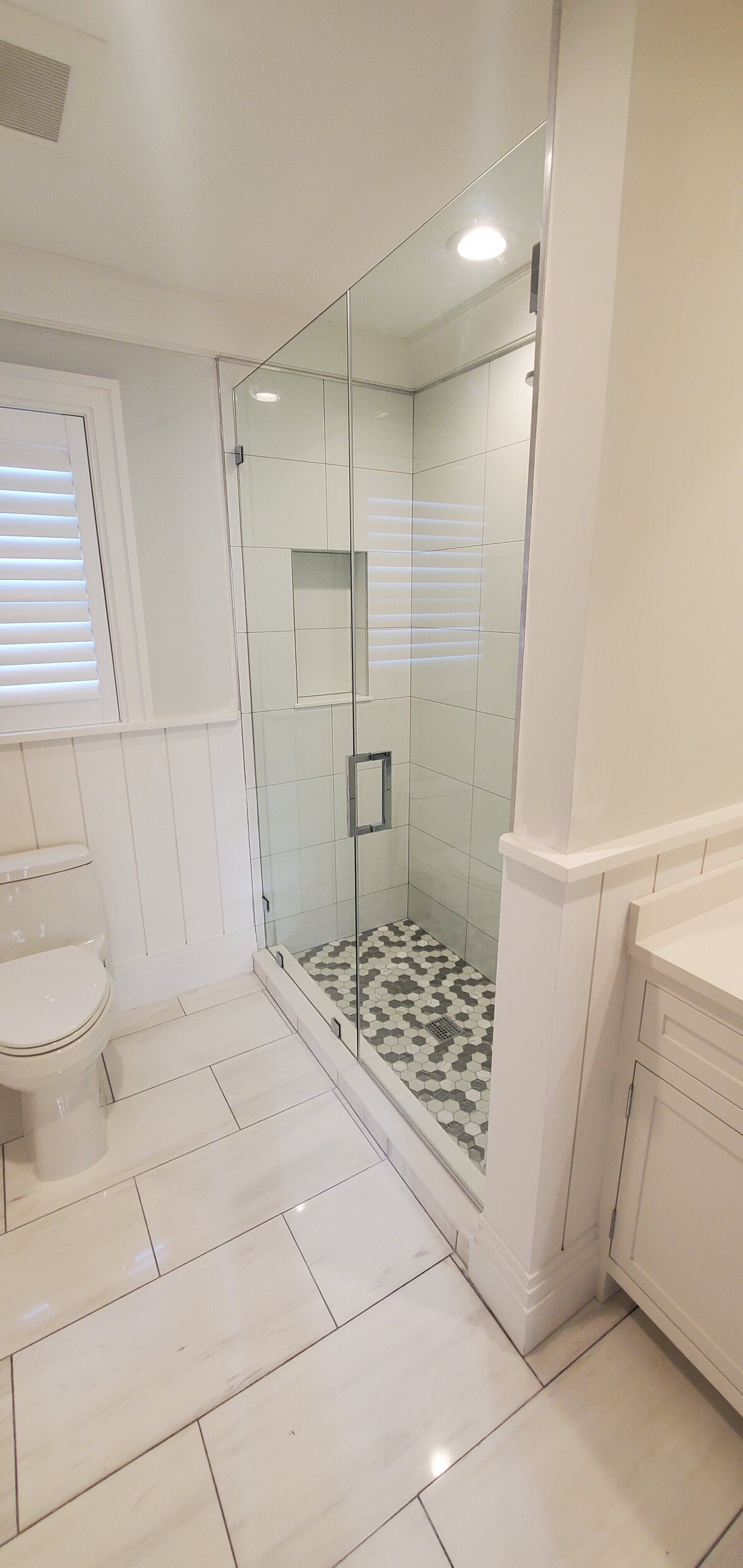 a bathroom with a walk in shower and a toilet .