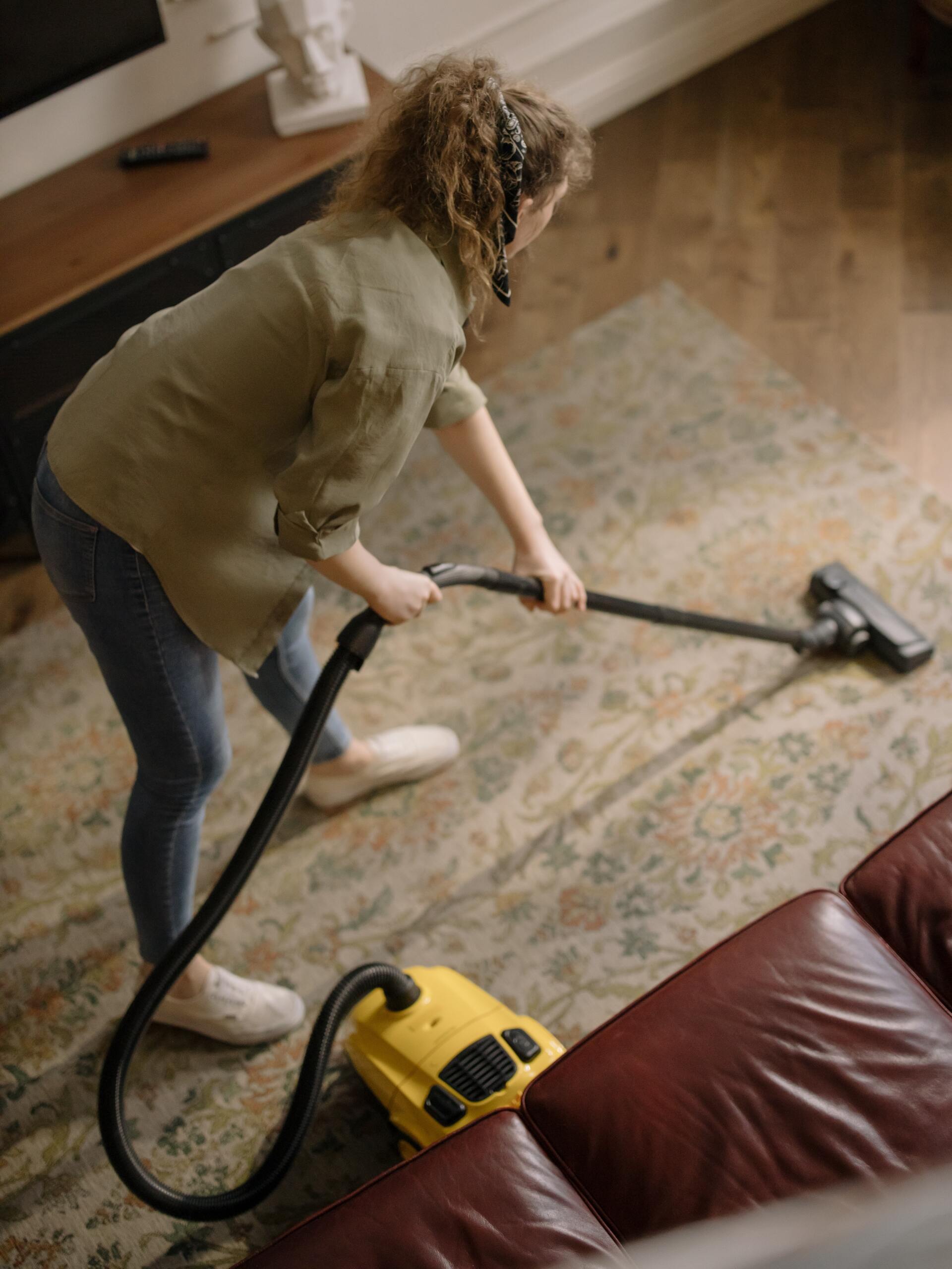 a woman vacuuming the floor in a living room.