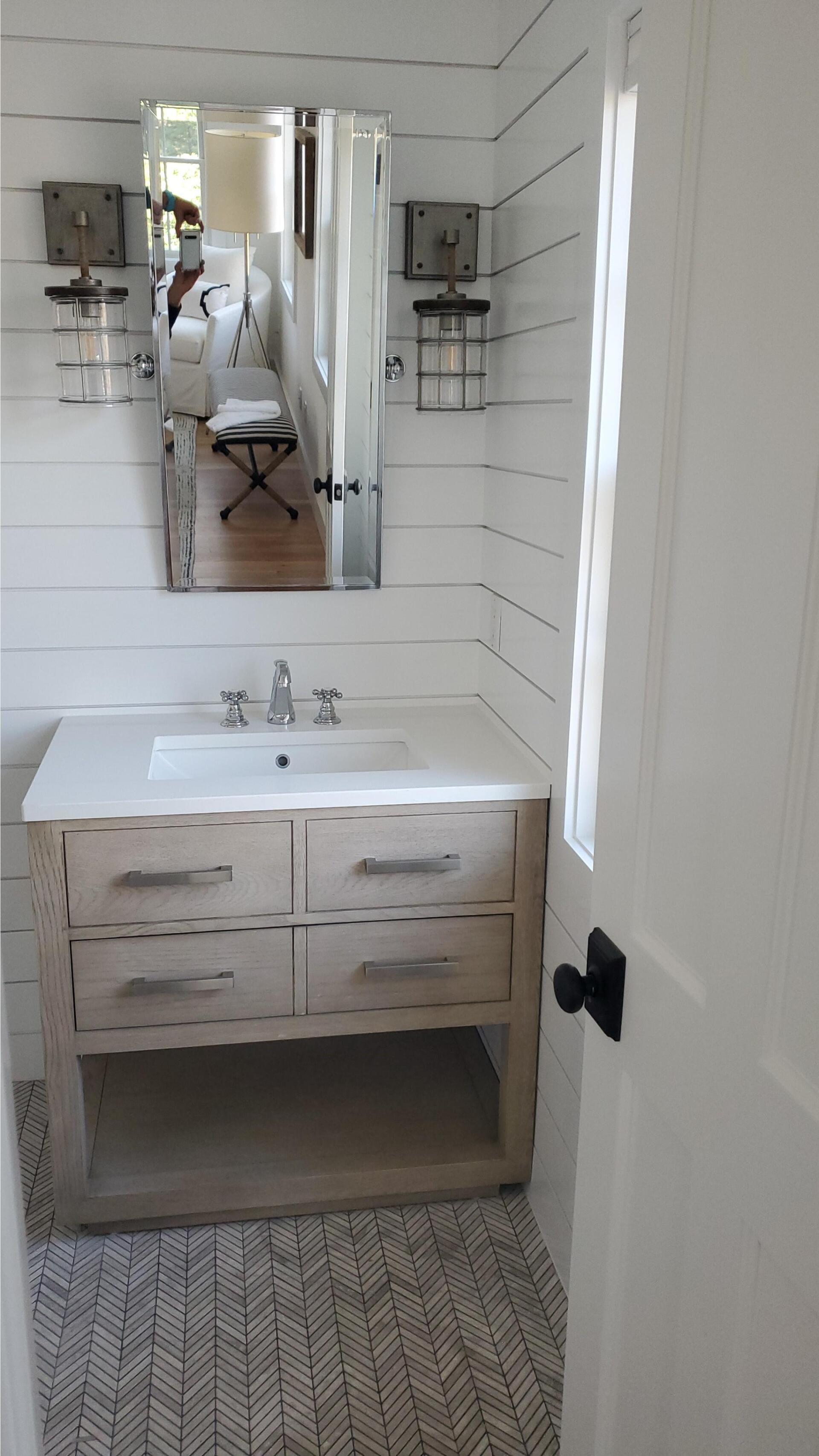 a bathroom with a sink , mirror and drawers .