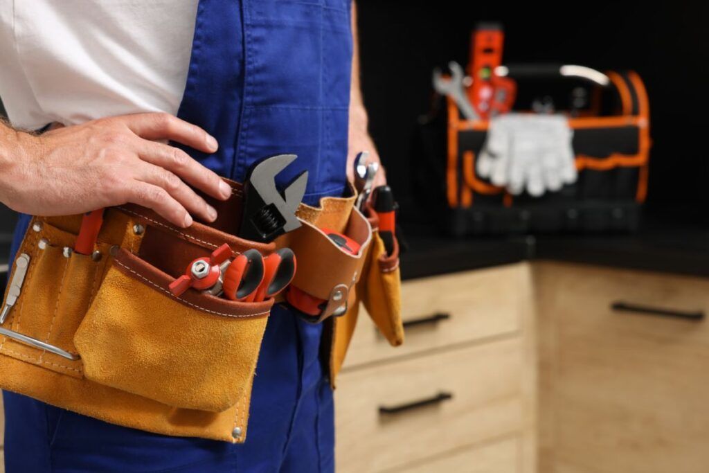A man is wearing a tool belt with tools in it.