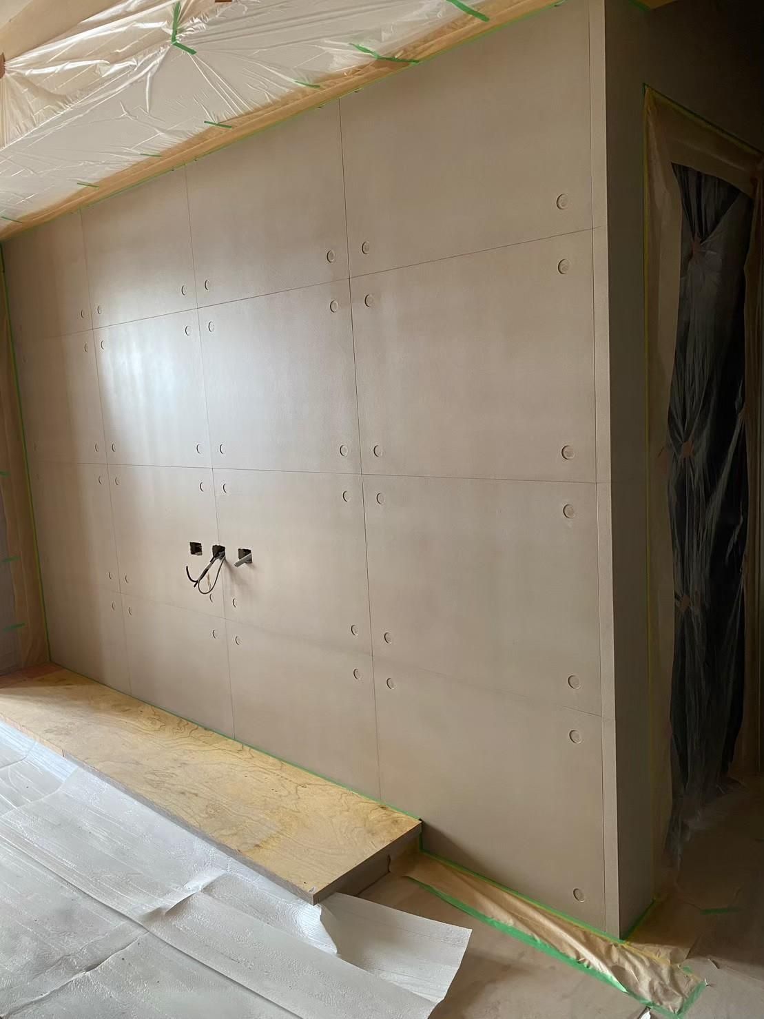 A room with a white wall and a green tape on the floor.