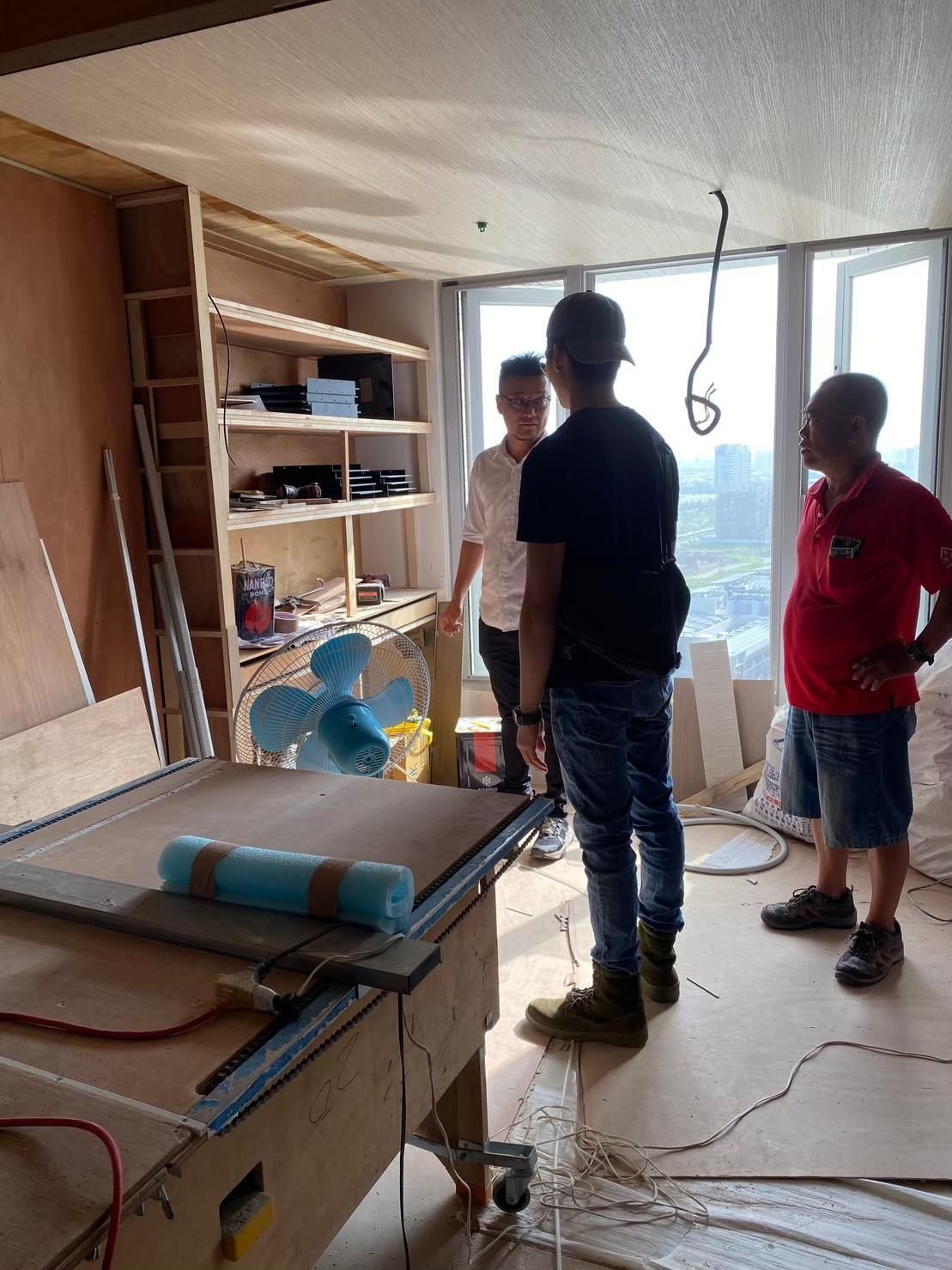 A group of men are standing around a table in a room.