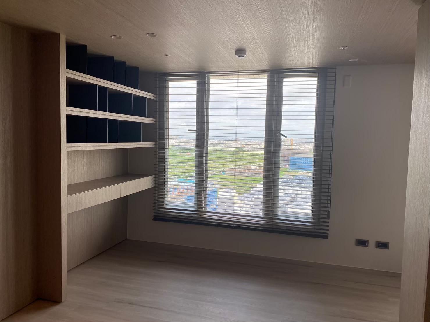 A room with a lot of windows and shelves in it.