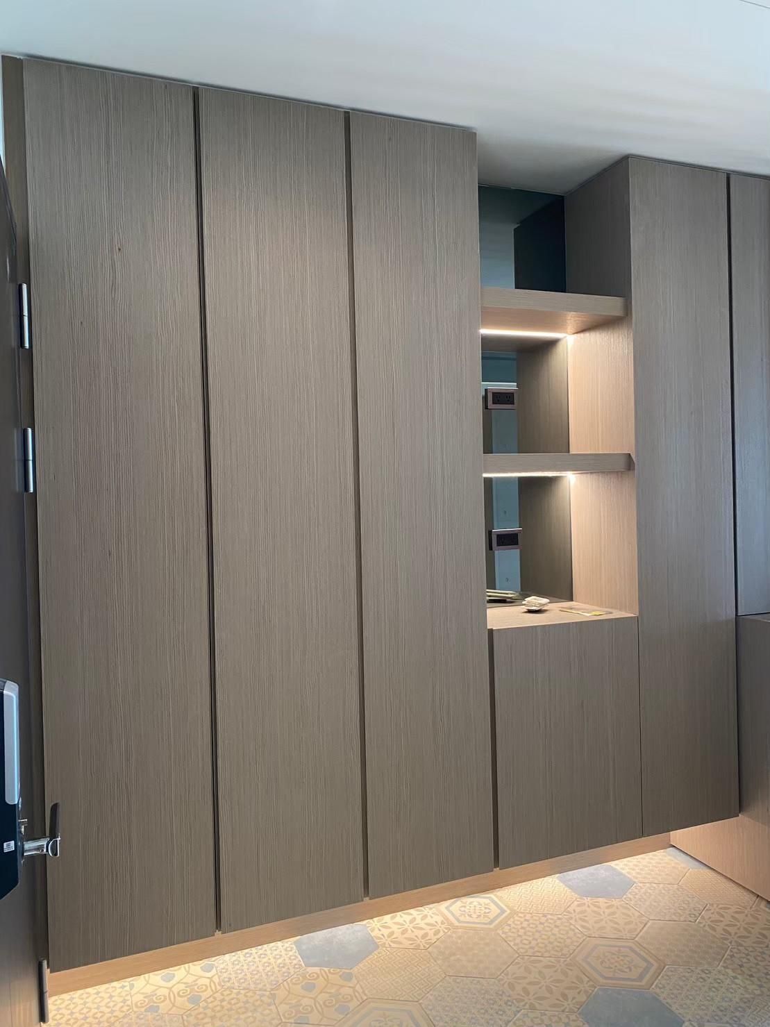 A room with a lot of wooden cabinets and shelves.