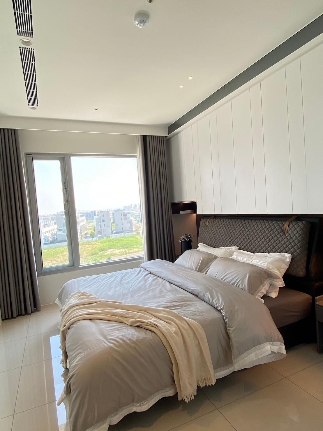 A bedroom with a large bed and a large window.