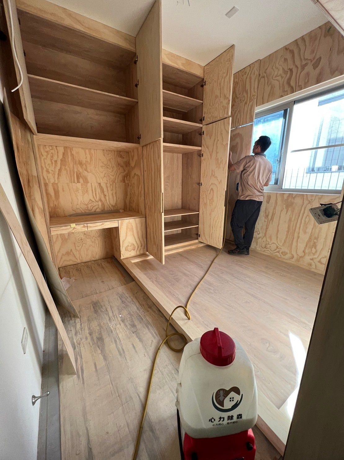 A man is standing in a room with a vacuum cleaner.