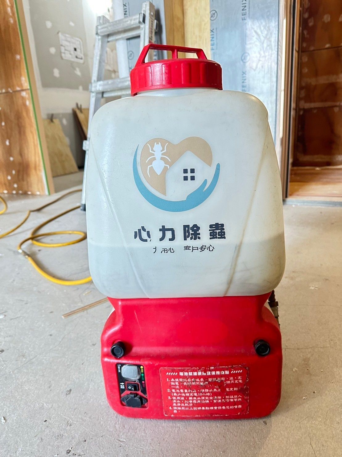 A red and white container with chinese writing on it is sitting on the floor.