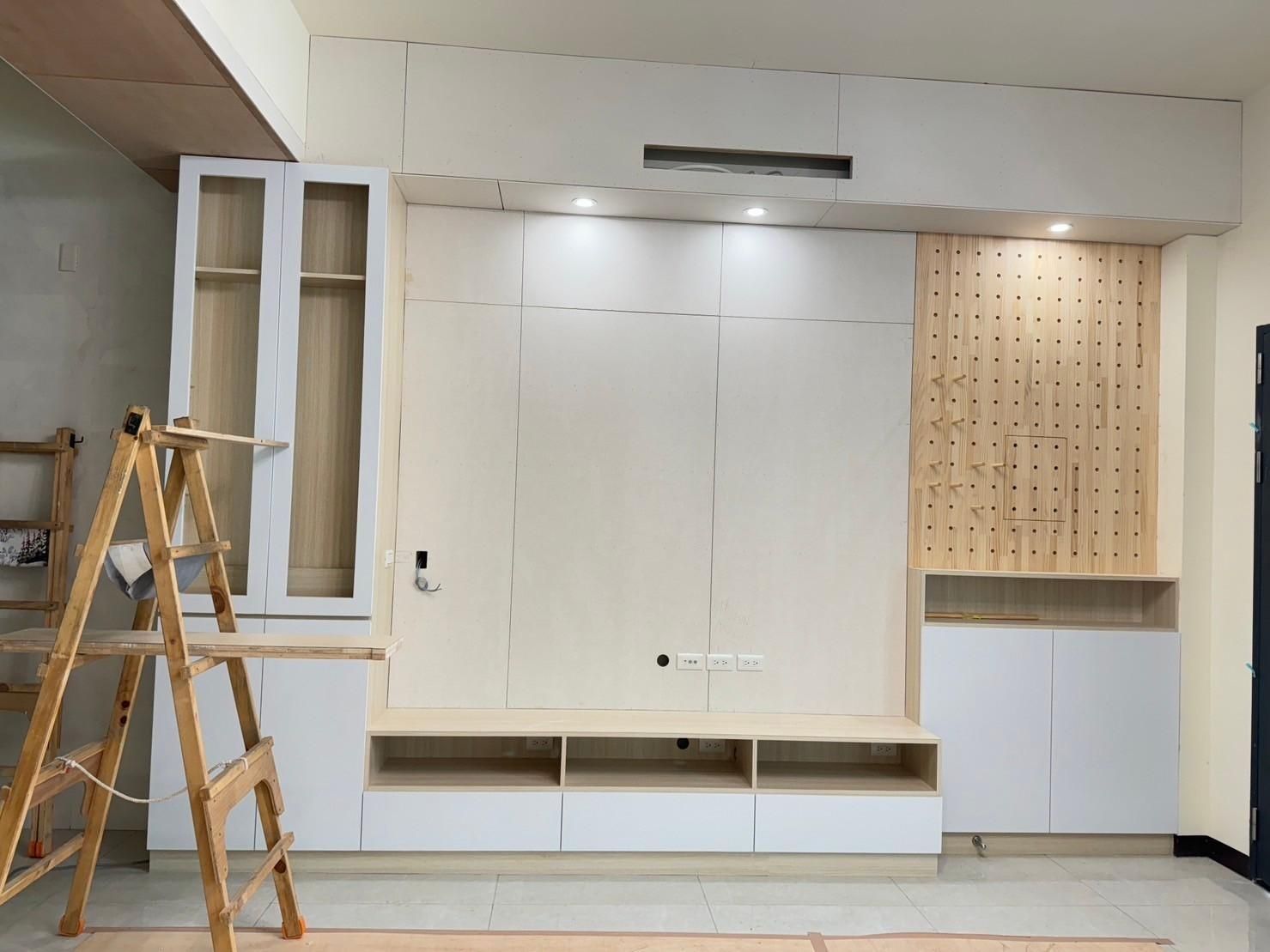 A living room with a wooden ladder in the middle of it.