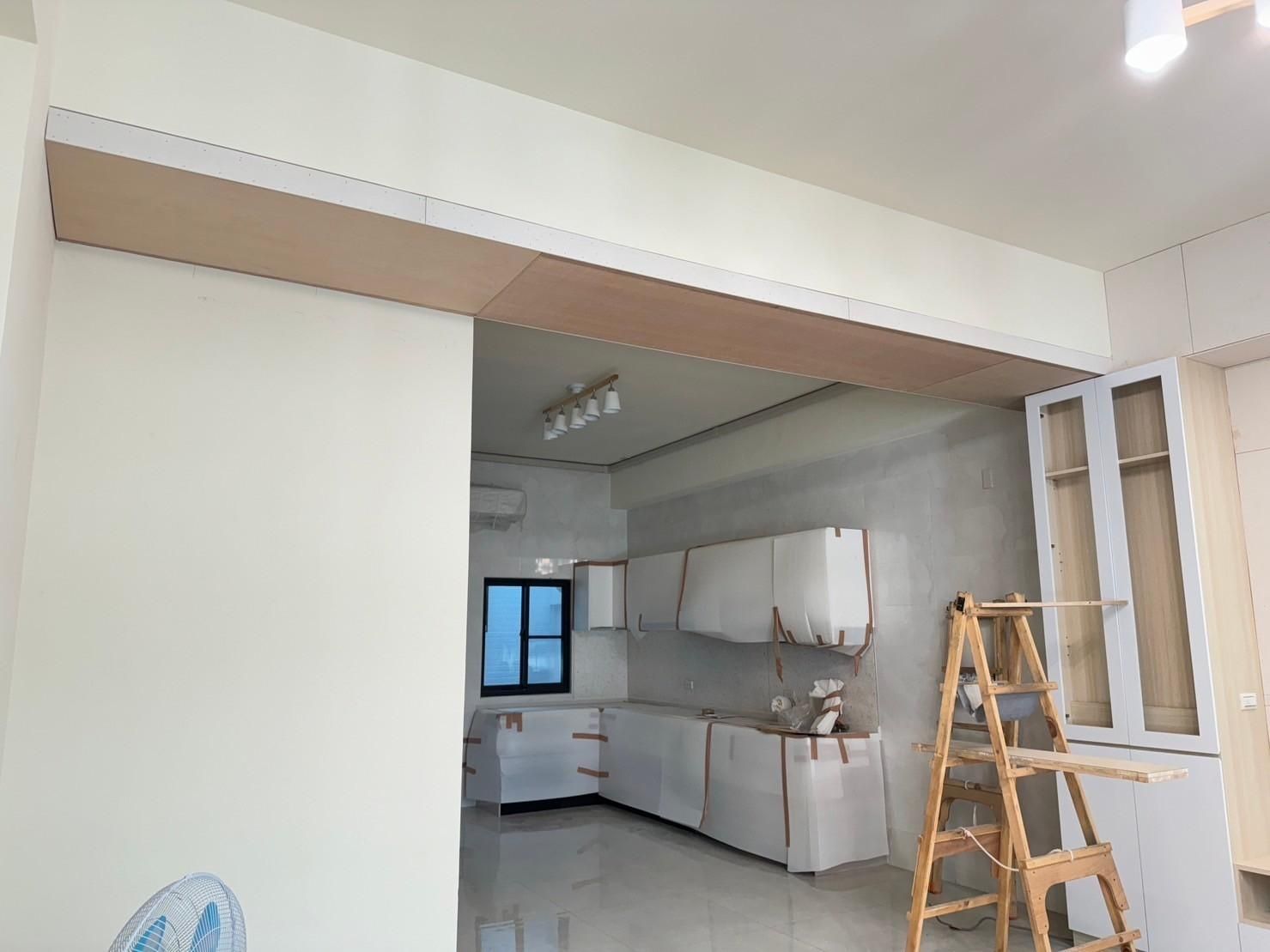 A kitchen under construction with a wooden ladder in the middle of the room.
