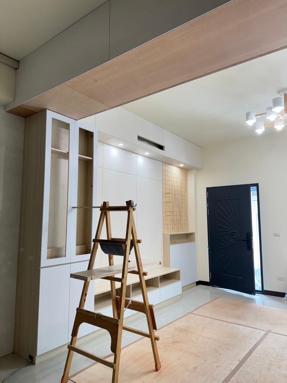 A wooden ladder is sitting in the middle of a living room.