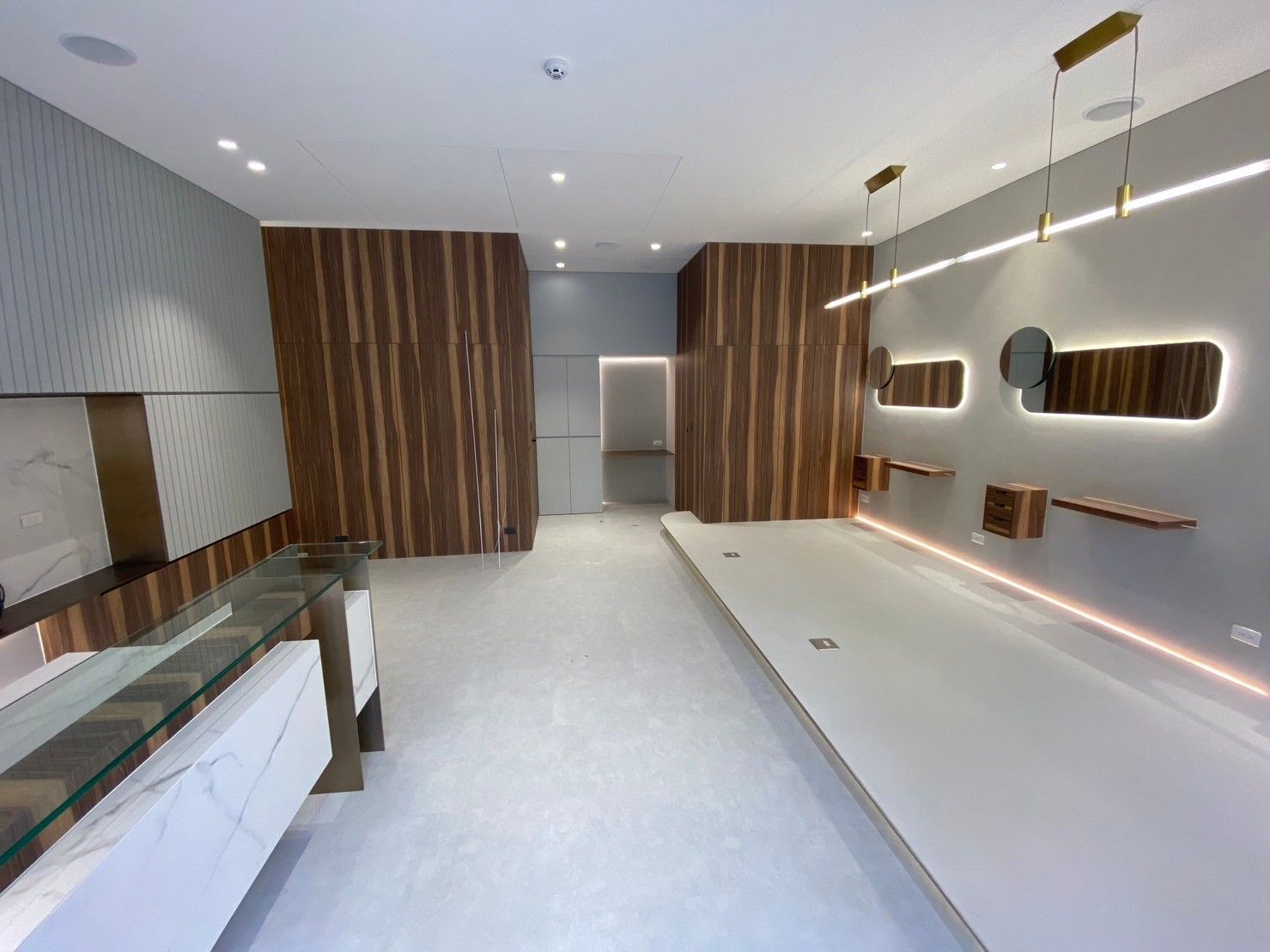 A large empty room with wooden walls and a glass counter.