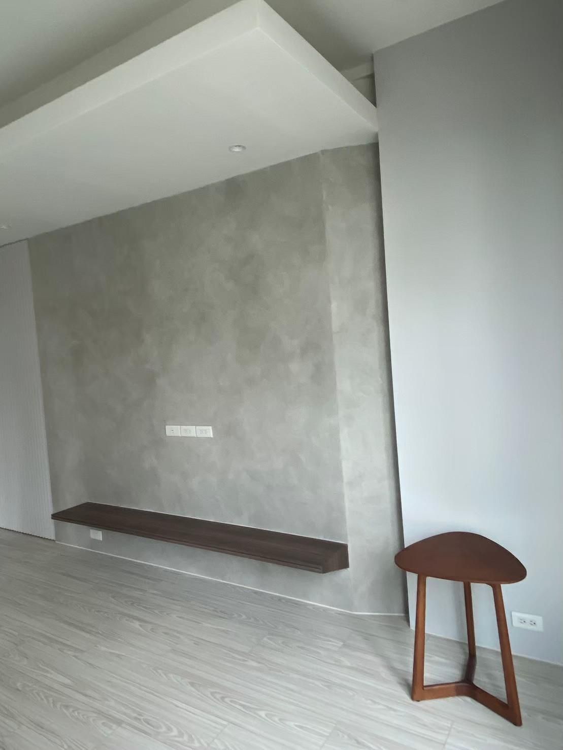 An empty room with a wooden table and a shelf on the wall