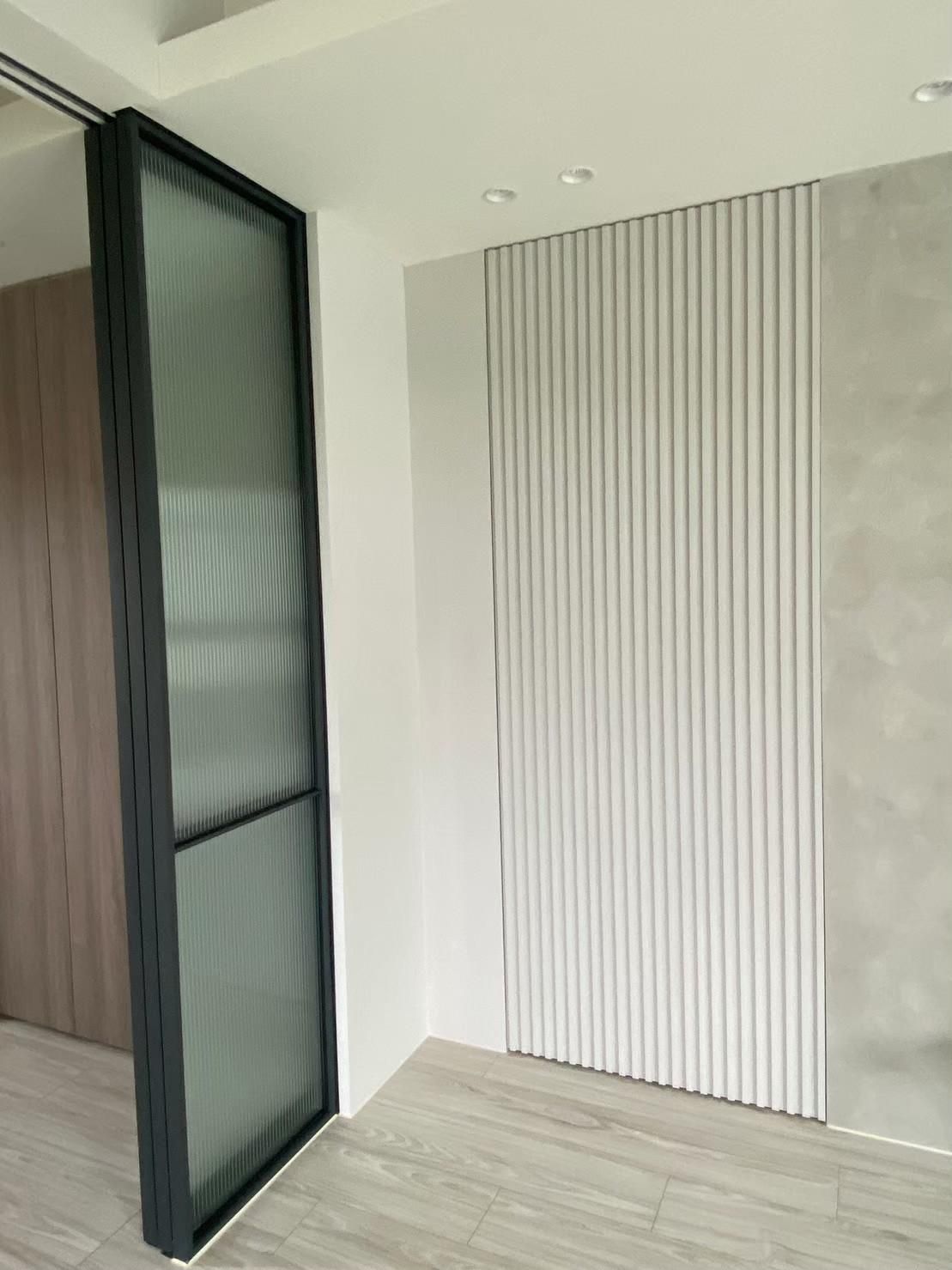 A room with a sliding glass door and a striped wall.