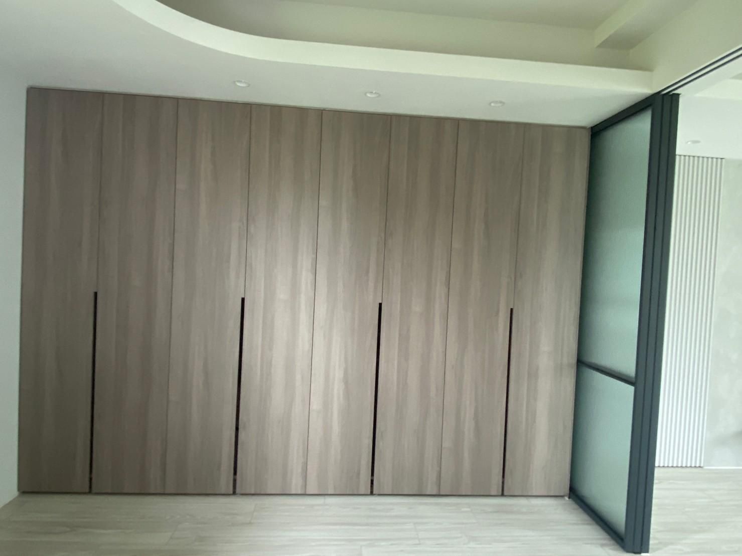 A room with a large wooden wall and a sliding glass door.