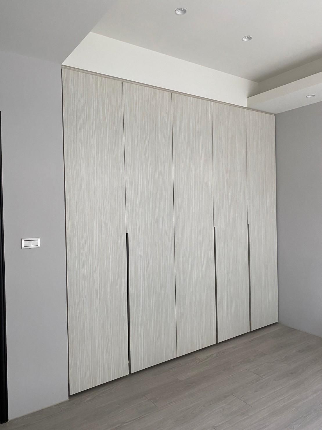 A room with a large white wall and a wooden floor.