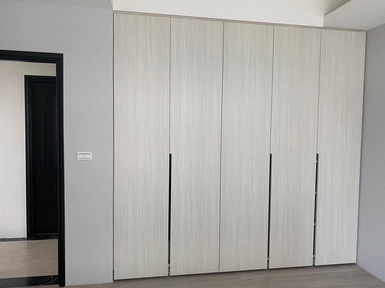 A room with a door and a wall with sliding doors.