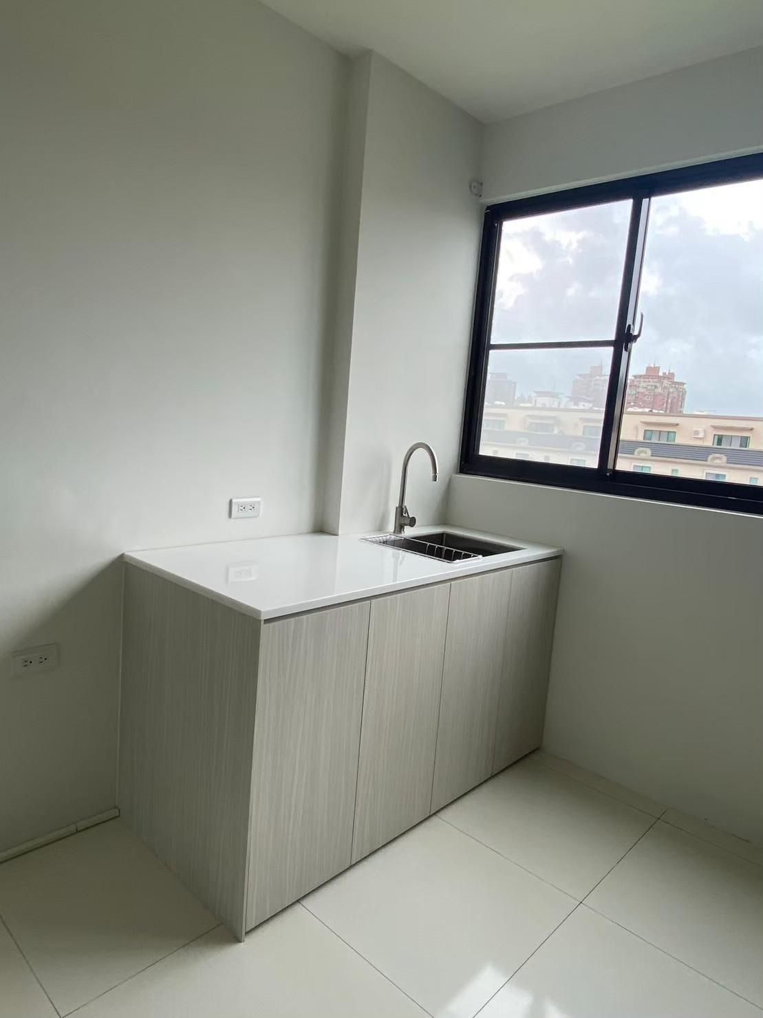 A kitchen with a sink and a window.