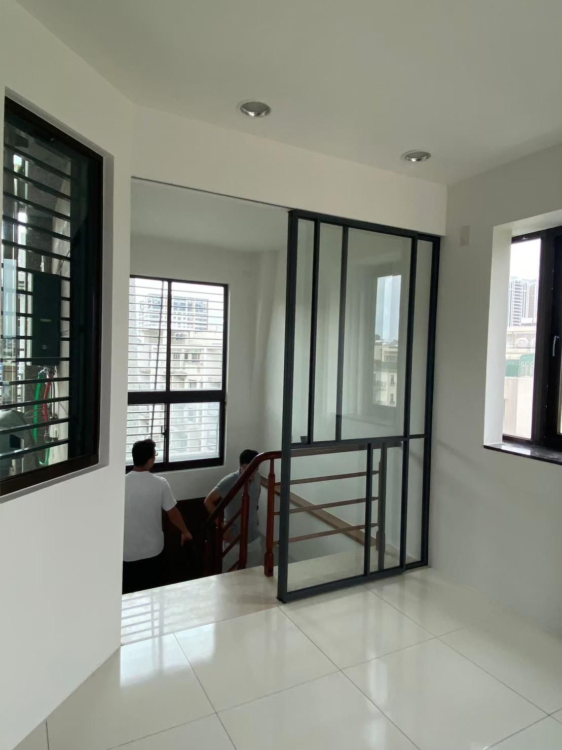 A man is sitting on a staircase in an empty room.