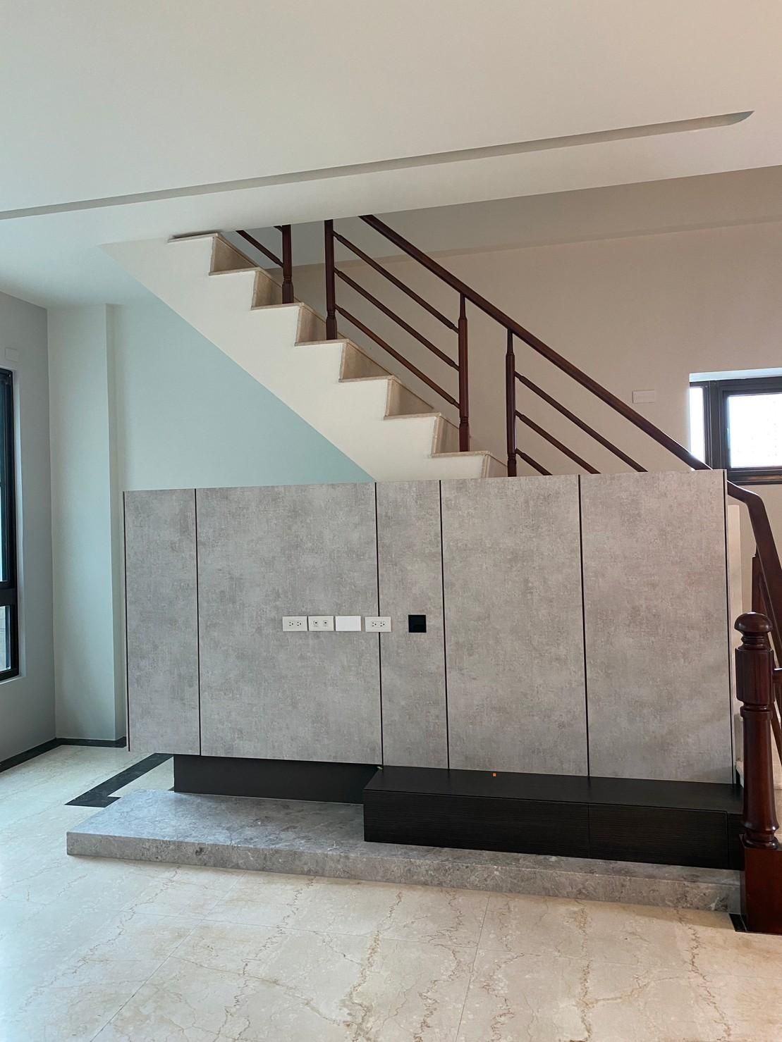 A living room with stairs leading up to the second floor