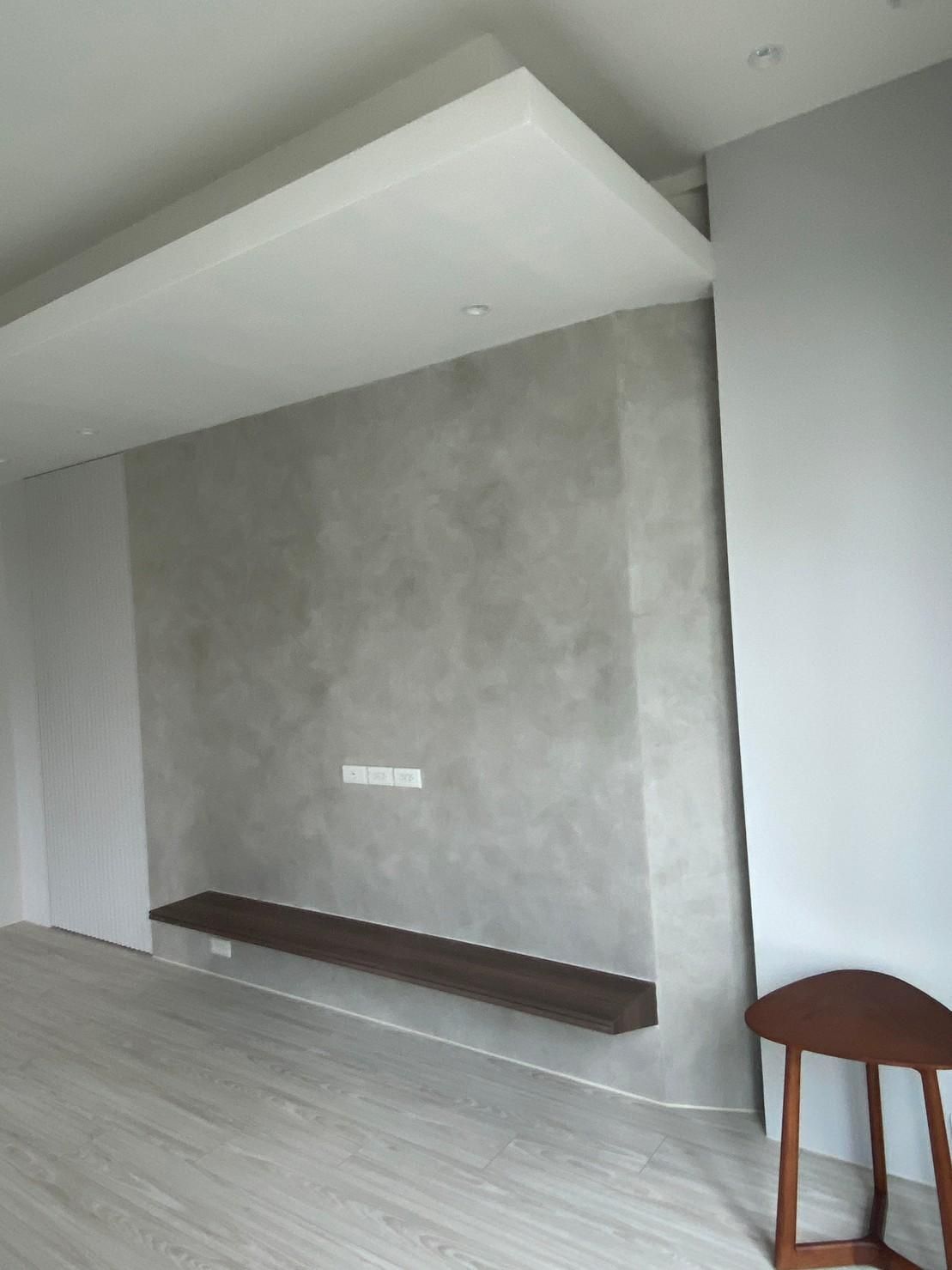 A living room with a shelf on the wall and a table