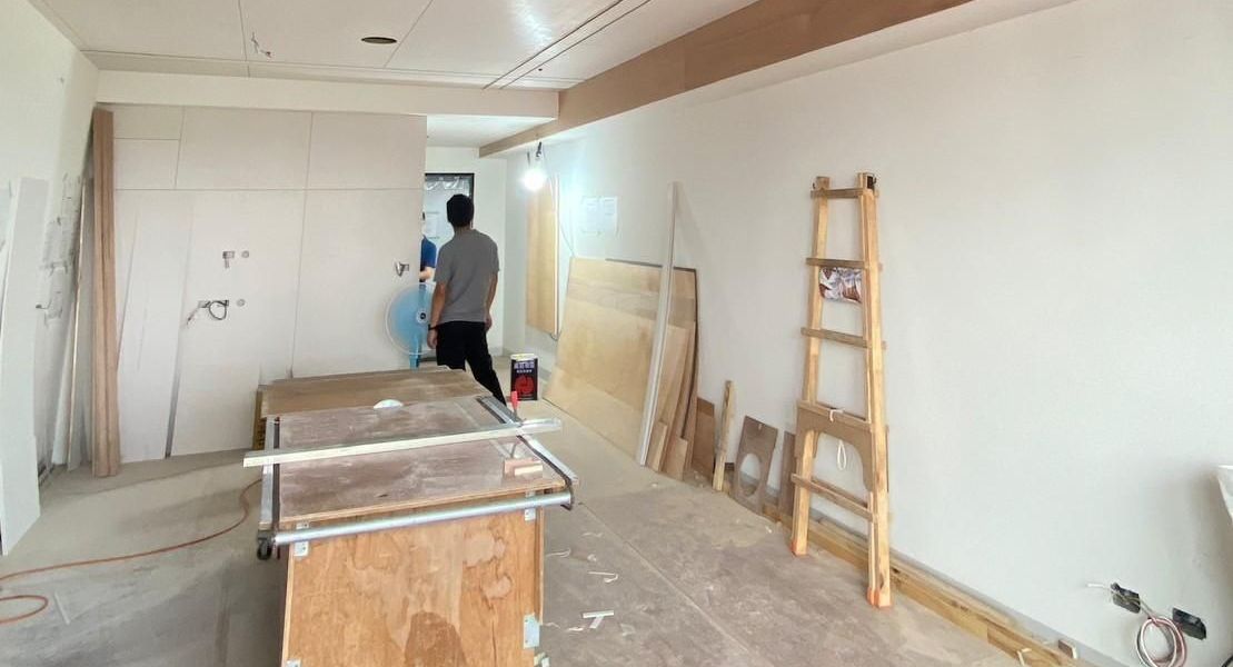 A man is standing in a room that is being remodeled.