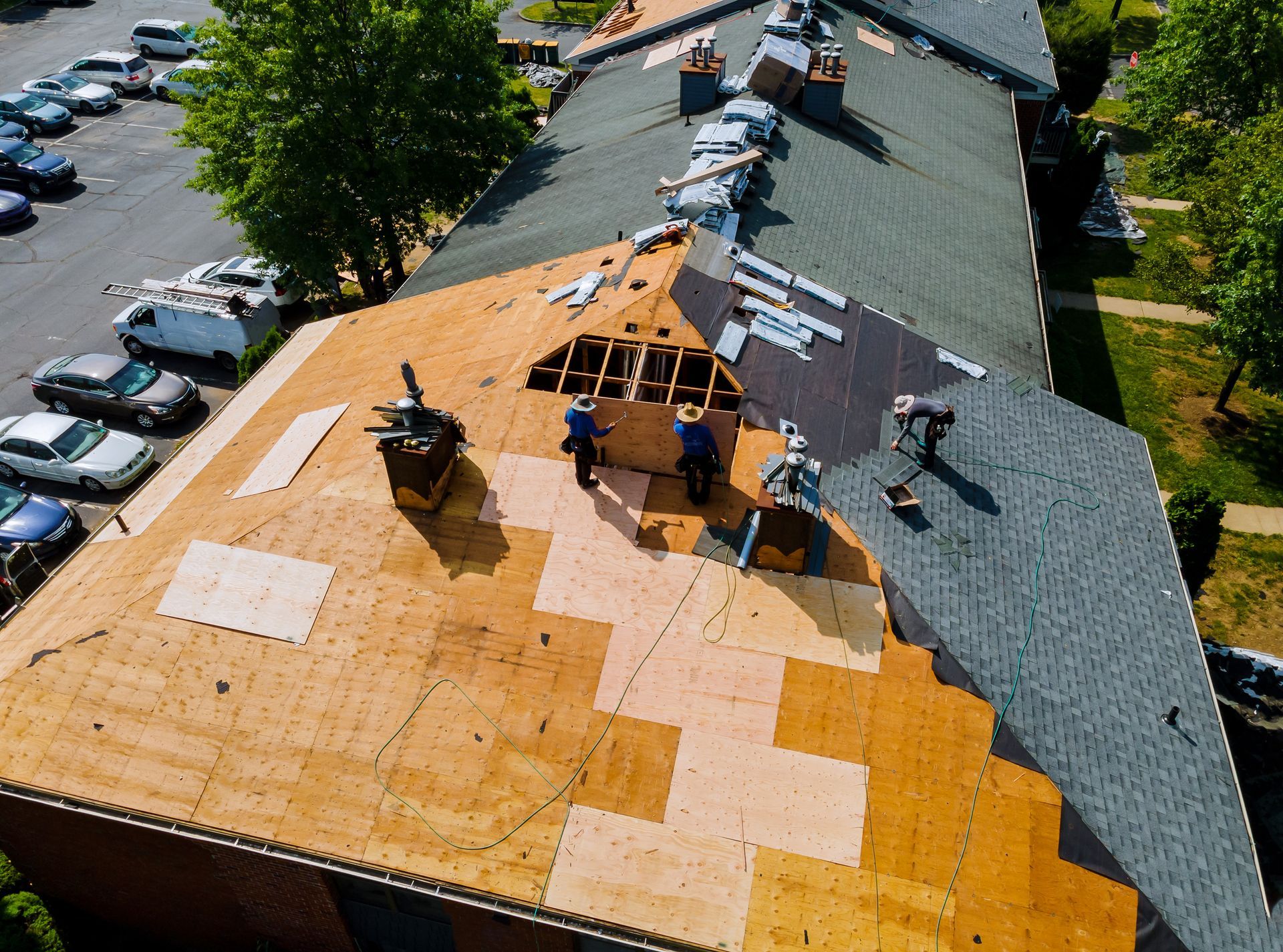 Roofing crew installing asphalt shingles on residential roof.