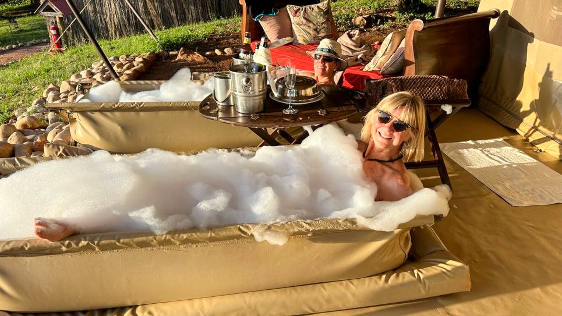 A woman is laying in a bathtub filled with foam.