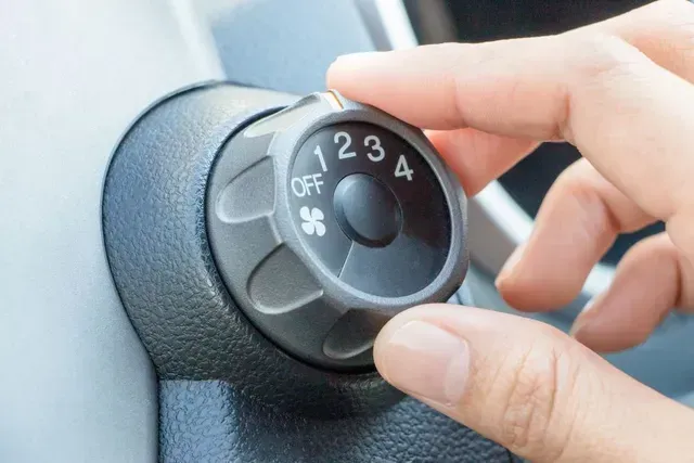 A Hand is Turning on a Knob of a Built-in Car Air Conditioner — Experienced Mechanic in Port Macquarie, NSW