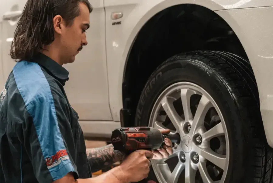 Fitting a Wheel with Machinery — Book a Car Service in Port Macquarie, NSW