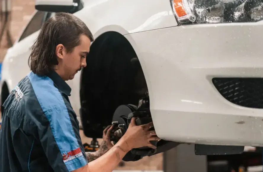 Man Inspecting and Fitting a Care Wheel — Book a Car Service in Port Macquarie, NSW
