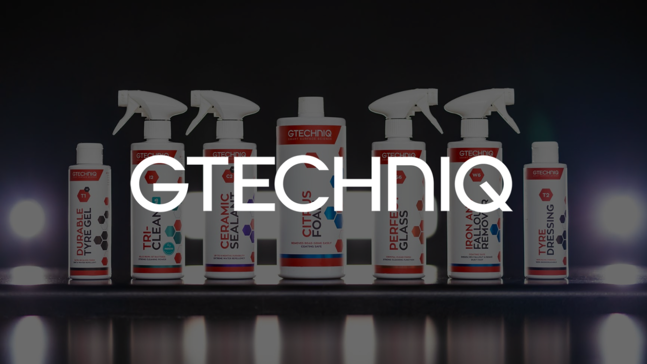 A group of spray bottles are lined up on a shelf.