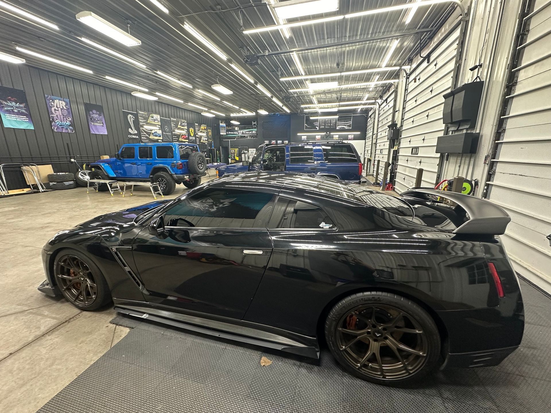 a man in a blue shirt is installing window tinting on a car .