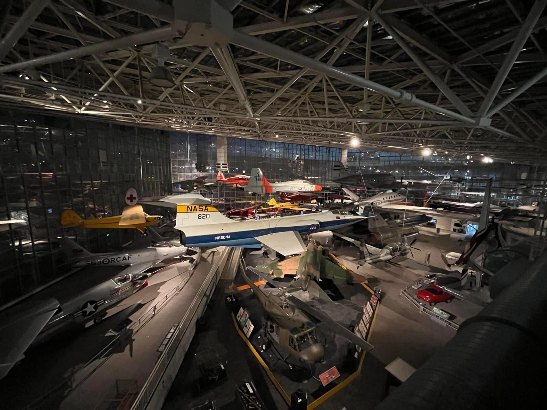 A large hangar filled with lots of planes and helicopters