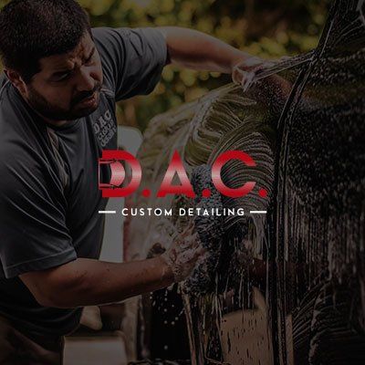 A man is washing a car with the logo for dac custom detailing